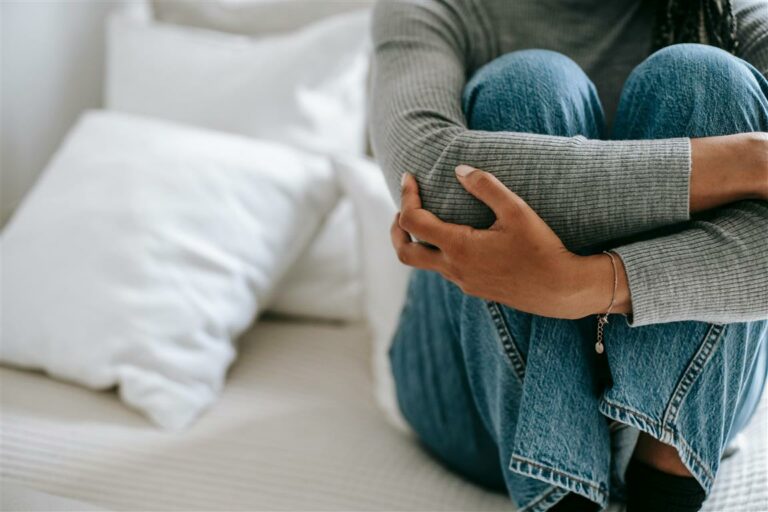 Anxious woman sitting on bed